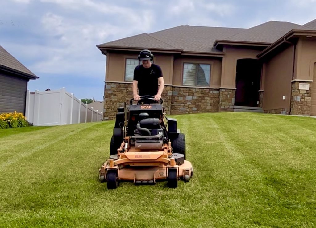 owner of Tiger Stripe Lawn Care out in the field maintaining turf